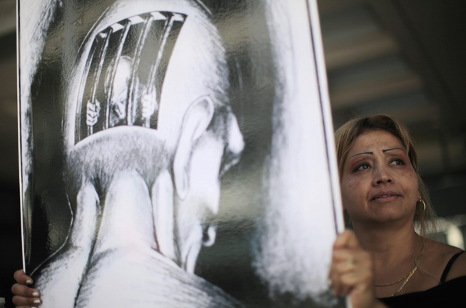woman holds placard in protest over prison conditions