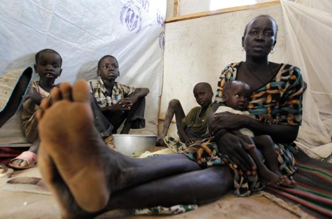 A refugee woman from Jonglei State in South Sudan sits inside a temporary shelter with her child at the registration centre in Kakuma refugee camp