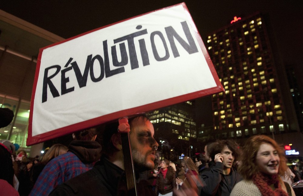 A protester holds a sign as students march in protest against tuition fee hikes, in downtown Montreal, Quebec