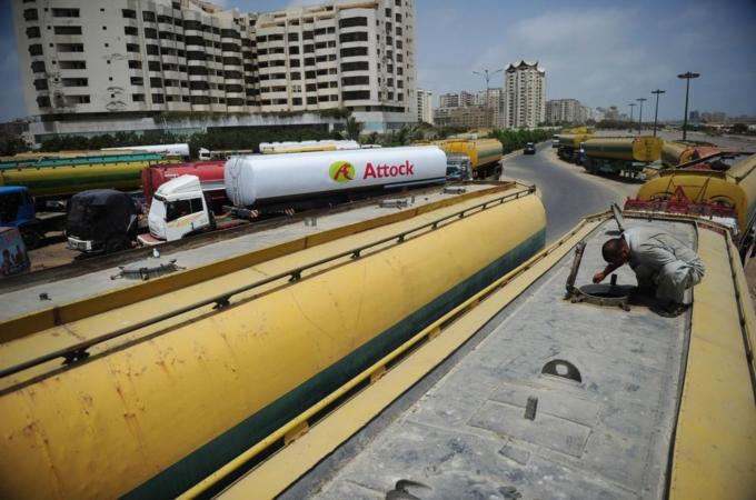 A Pakistan driver checks tank of his fue