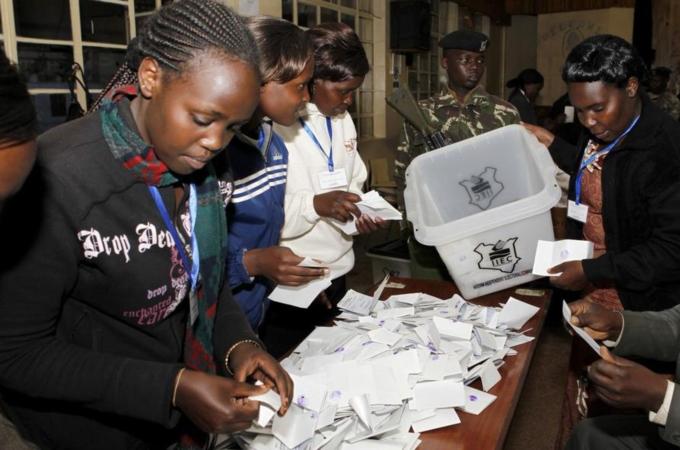 Electoral officials sort out ballots before counting votes at a polling centre in Eldoret town