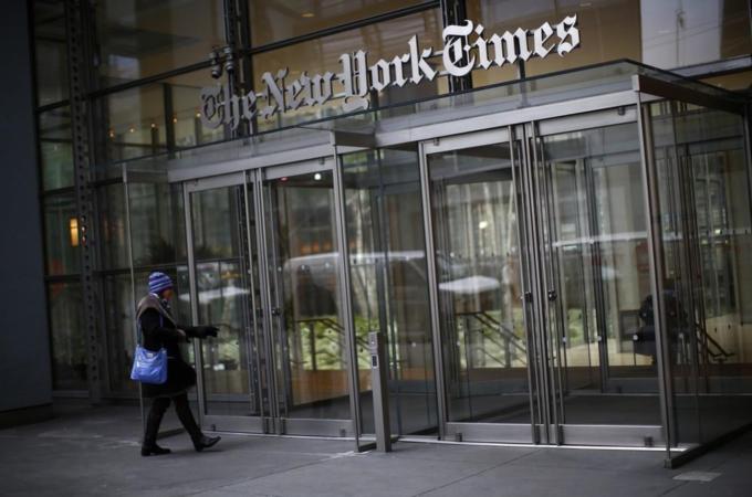 A woman walks into the New York Times building in New York