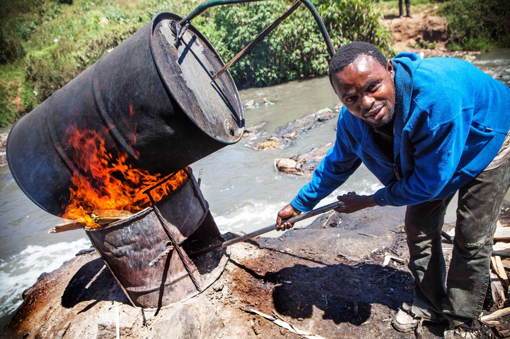 Changaa is often brewed in rivers contaminated with sewage. In Mathare slum, rich Kenyans and Indian businessmen invest in its production, but never come into the slum. They just collect the money through "runners". 