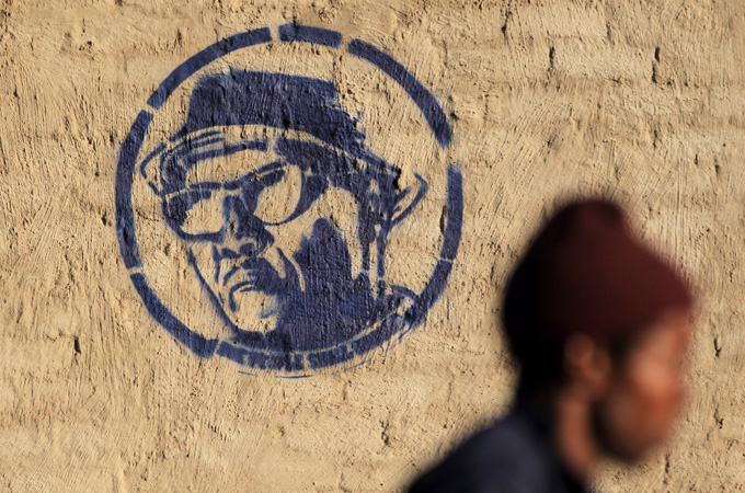 A person walks past a mural of Nelson Mandela in Johannesburg, South Africa, Monday June 10, 2013. A mural depicts a photograph of Nelson Mandela working in the Robben Island prison garden in 1977 titled “A prisoner in the garden”. Mandela has been hospitalized with an occurring lung infection. The latest government report says that he remains in a serious but stable condition. (AP Photo/Themba Hadebe)