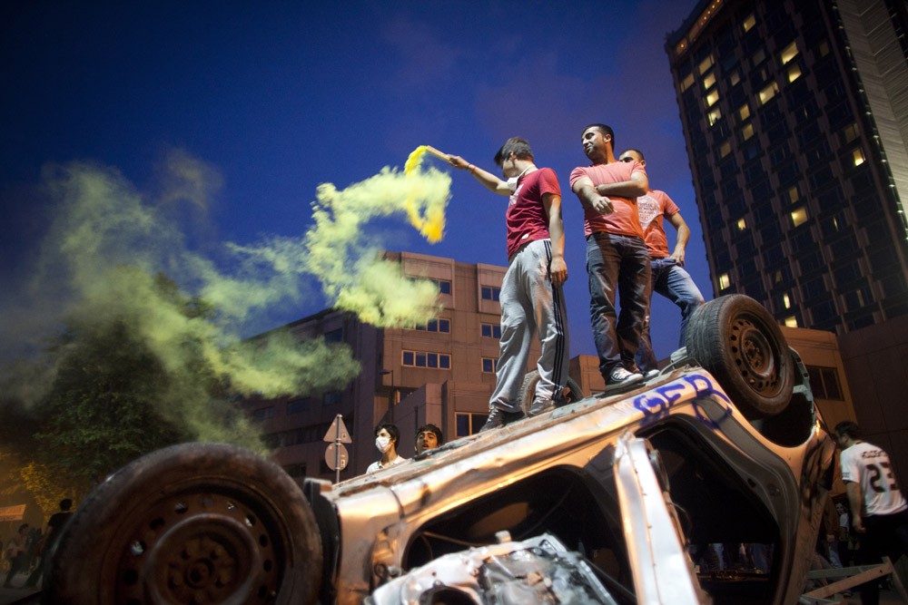 <p>A young man stands on top of a burnt car in Taksim Square. The square, located across from Gezi Park, has been referred to Turkey(***)s Tahrir Square by some commentators. The government says such a reference is absurd as Turkey is a democracy and Egypt was a dictatorship during the Tahrir protests. </p>