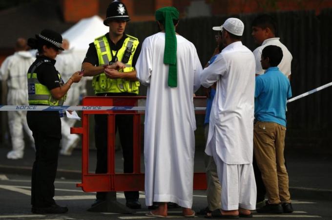 Residents speak to police officers guarding a cordon after an explosion in Tipton, central England
