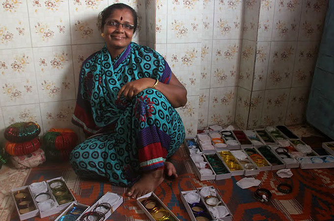 Kalpana Shinde runs a small business in bangles and saris from her Dharavi home [Asad Hussain/Al Jazeera]