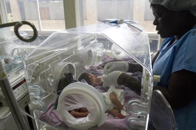 A Kenyan nurse attends to four babies squeezed in an incubator due to a health workers' strike [AFP/Getty Images]