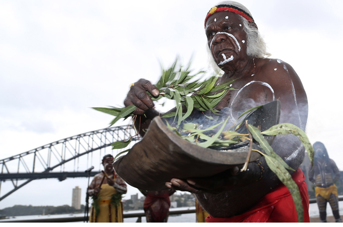 An aboriginal elder carries burning gum leaves during a ceremony on Australia Day in Sydney in January [AP]