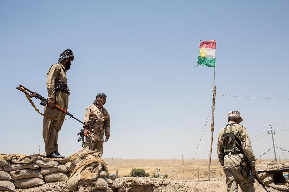 <p>Kurdish Peshmerga fighters walk through their base on the outskirts of Kirkuk. After the disintegration of the Iraqi military in Kirkuk, Peshmerga forces quickly seized the city they have long seen as theirs, and have refused to return it to it the Iraqi government.</p>