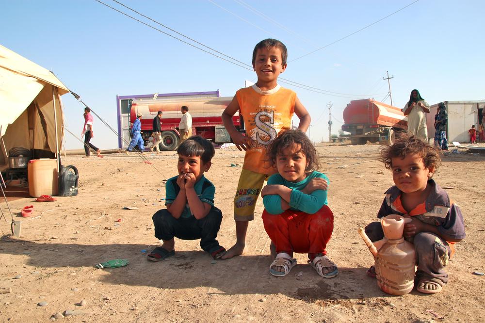 <p>Four children from Mosul collect water for their families at the Khazir refugee camp.</p>