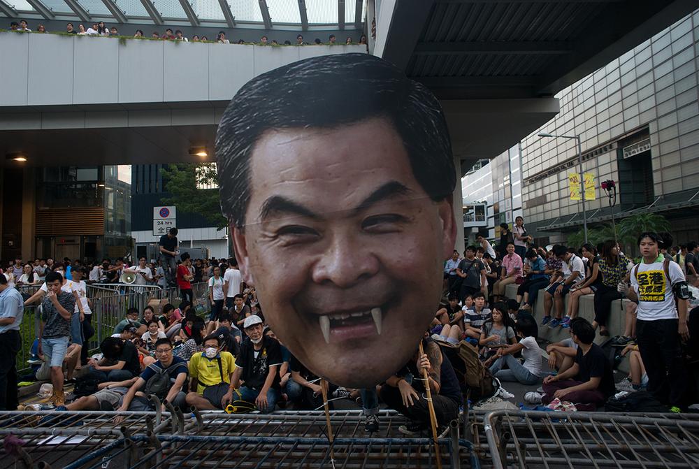 <p>A protester holds a defaced picture of Hong Kong Chief Executive Leung Chun-ying during the occupation of government headquarters in Admiralty district on Saturday.</p>