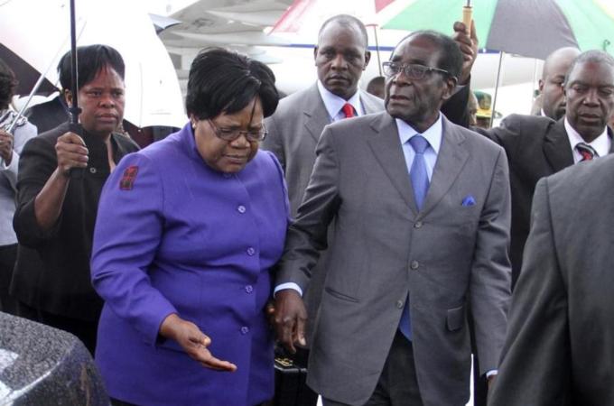 President Robert Mugabe is greeted by Vice President Joice Mujuru as he returns to Harare [Reuters]