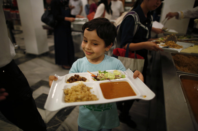A Muslim boy breaks his fast during the holy month of Ramadan at the Tokyo Mosque [Reuters]