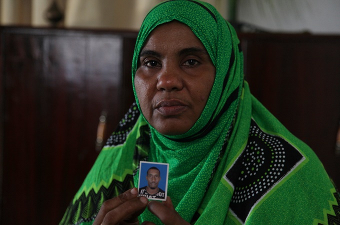 Nadiya Ahmed, mother of Idris Mohamed, holds up a photo of her slain son [Zahra Moloo/Al Jazeera]