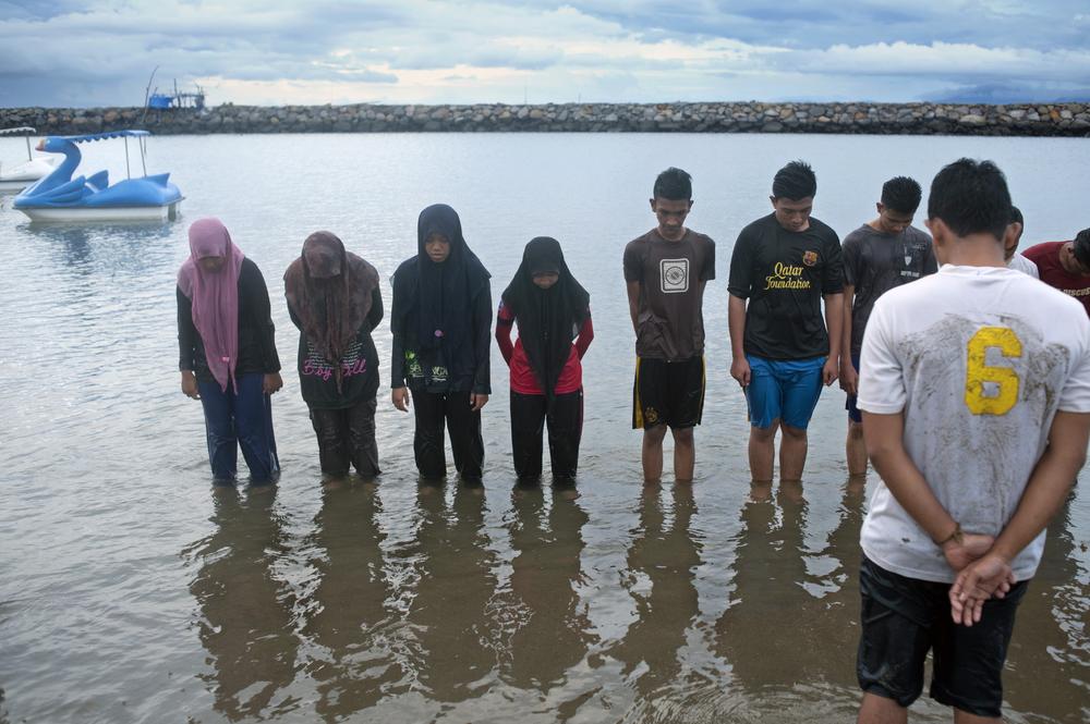 <p>University students pray after a swimming class on Ule beach in Banda Aceh. These classes are among the few interactions between men and women.</p>