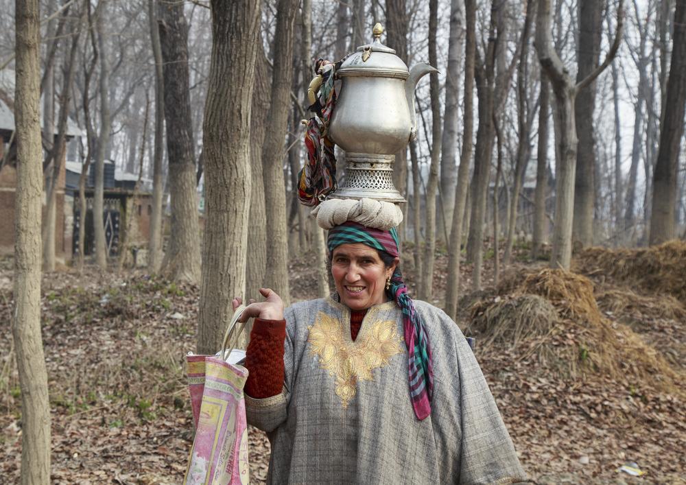 A woman from Halumulla village takes morning tea to the workers at her husband’s bat-manufacturing unit through the flooded, mud marked Kashmir willow trees.