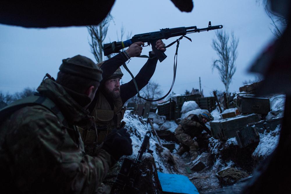 A volunteer from the Ukrainian Sich Battalion fires blindly from the last trench before no-man's-land on the front line in Pisky, just outside of Donetsk.