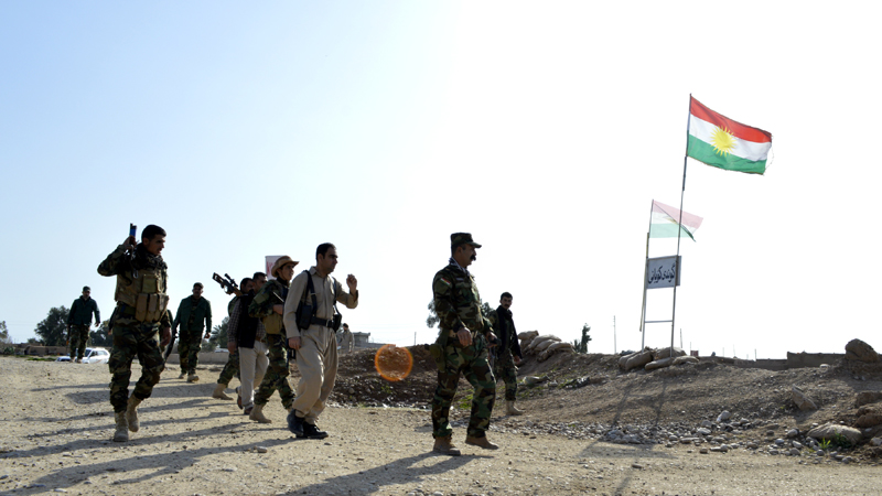 Kakai fighters walk towards the main road in the village of Kobane, in the southern part of Kirkuk province to check out ISIL positions a couple of kilometres away [Mohammed A Salih/Al Jazeera]