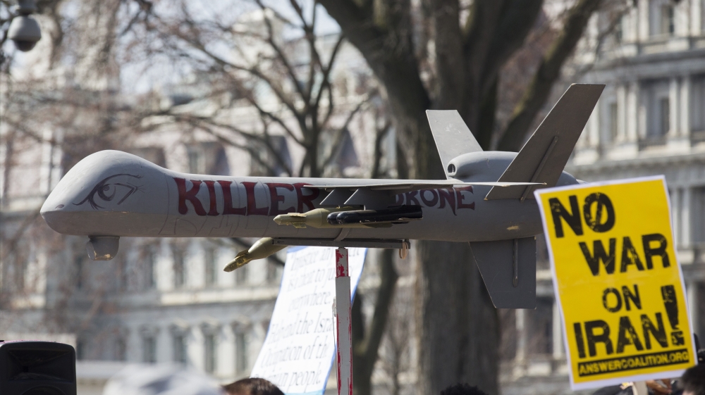 Protesters carry placards near a fake drone in front of the White House during an anti-war march in Washington, DC [AFP]