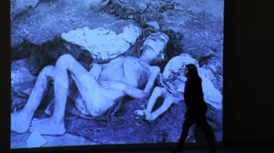A woman walks past an archive photograph during an exhibition at the Armenian Genocide Museum in Yerevan [AFP]