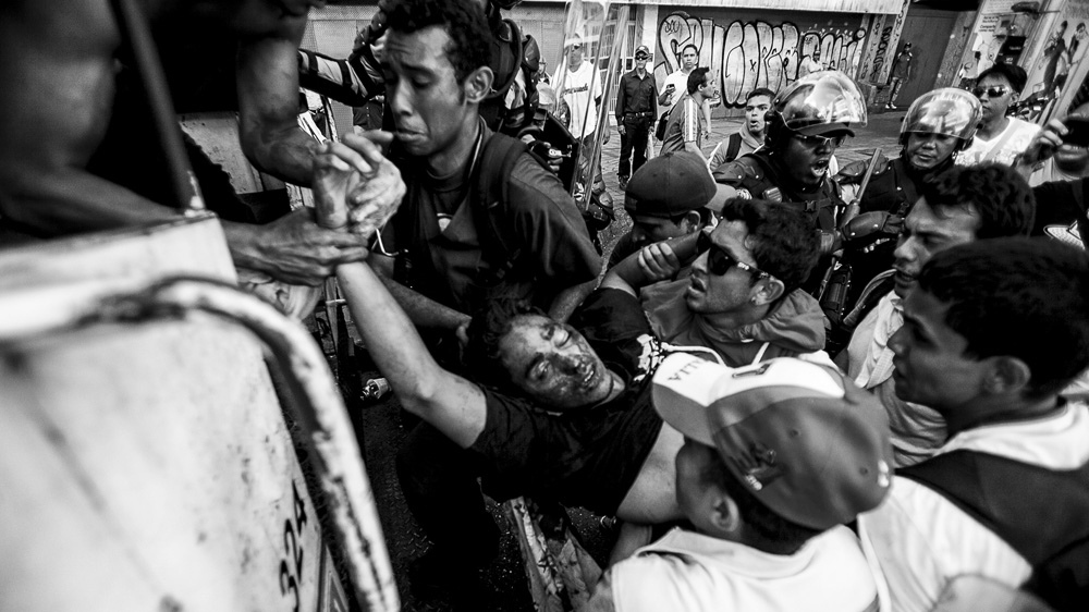The body of Bassil Da Costa is lifted into a police vehicle [Alejandro Cegarra]