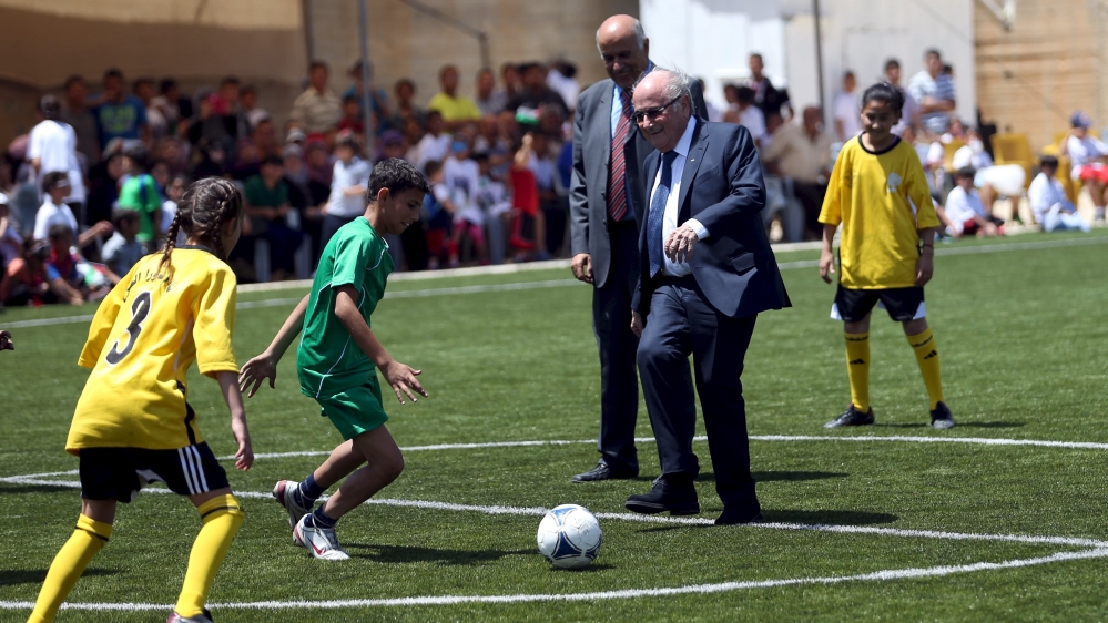 FIFA chief Sepp Blatter plays soccer with Palestinian children during his visit to Dura al-Qar'' village in the West Bank city of Ramallah