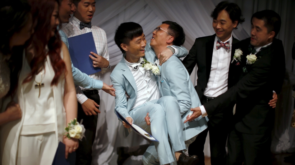 Duan Rongfeng lifts his new husband Li Tao at a group wedding for same-sex couples in West Hollywood