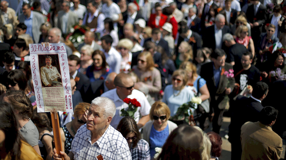 A man holds a picture of Soviet dictator Josef Stalin as he attends Victory Day celebrations [Reuters]