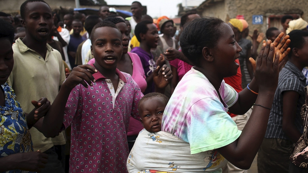 A protester dances as she carries her child in Bujumbura, Burundi [REUTERS]
