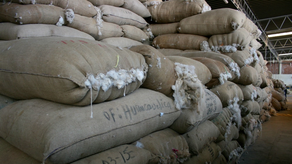Burlaps of alpaca wool sent from all over Peru's mountain regions lie in a warehouse in Arequipa [Alex Pashley/Al Jazeera]  