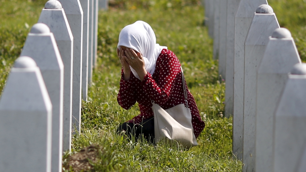 A woman prays near the grave of her relative, among 136 newly identified victims of the 1995 Srebrenica massacre lined up for a joint burial in Potocari