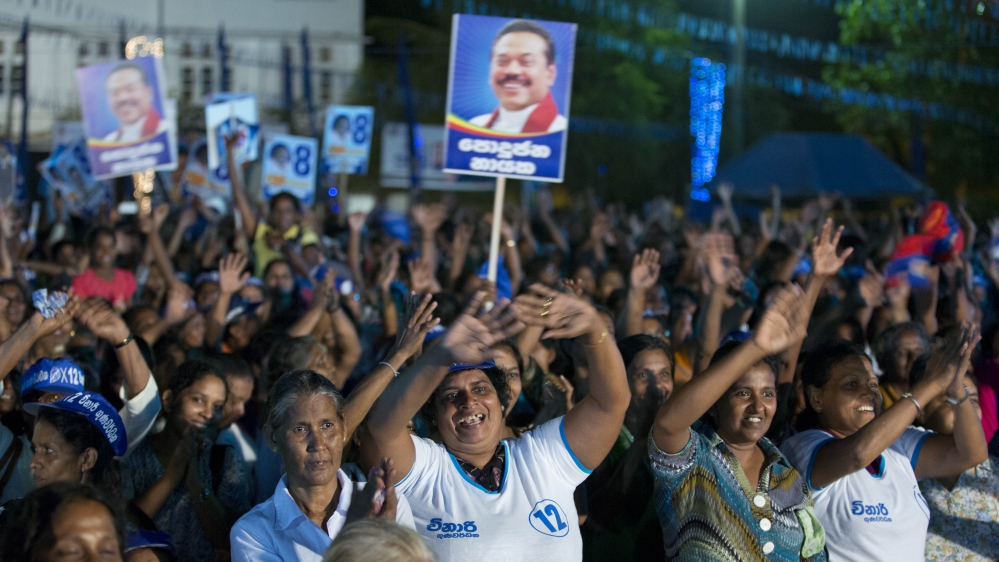 Supporters of Sri Lanka''s former president and parliamentary candidate Mahinda Rajapaksa display placards of him and applaud during a political rally to promote c
