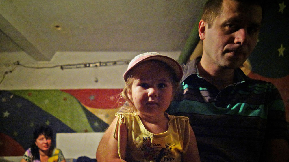 Sergei Petrovich and his family live underground to escape artillery fire, but have paid an emotional price [Filip Warwick/Al Jazeera]