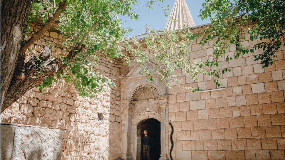 In the leafy calm of the Yazidi temples in Lalish, the spiritual home of the Yazidi community, visitors and pilgrims are required to walk barefoot [Andrea DiCenzo/Al Jazeera]