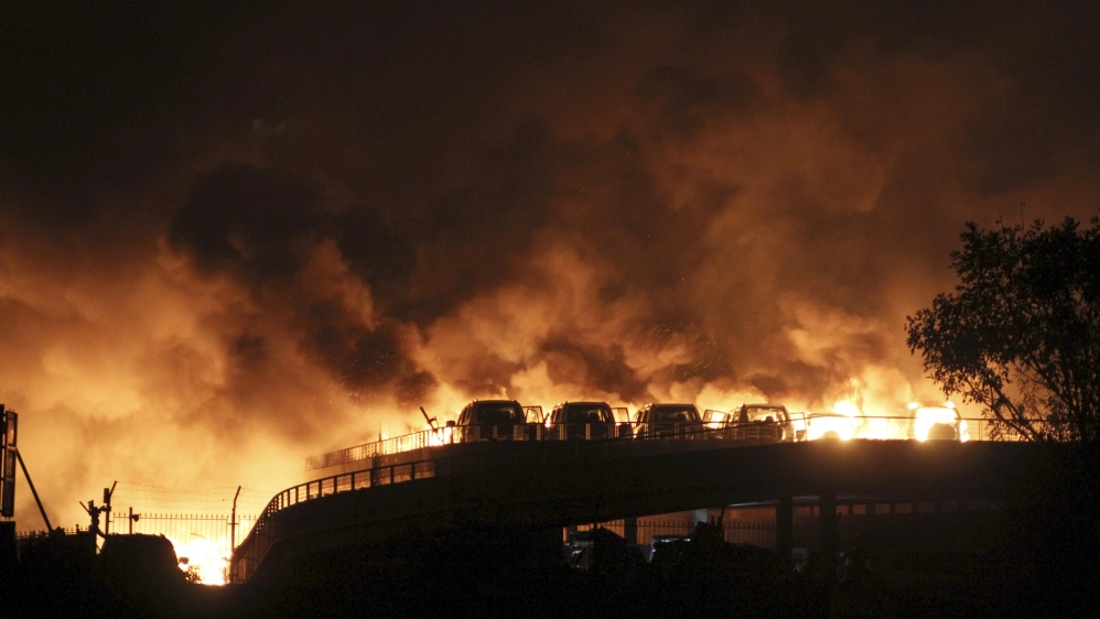 Vehicles are seen burning after blasts at Binhai new district in Tianjin municipality