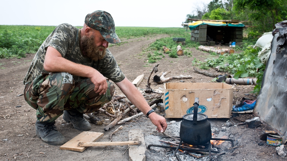 Dragon, his nom de guerre, prepares some hot water. On the first line, the soldiers don't have any electricity or spare water for showers. [Virginie NGUYEN HOANG] 