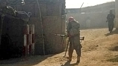 Taliban fighters take positions after occupying a police station for several hours on Monday [AP]