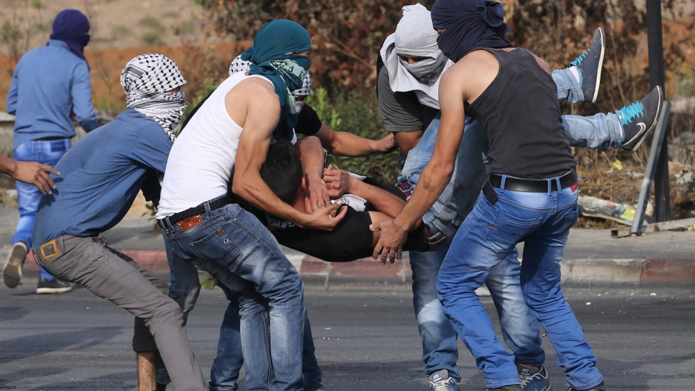 Wounded Palestinian protester is evacuated during clashes with the Israeli troops near the Jewish settlement of Bet El, near the West Bank city of Ramallah