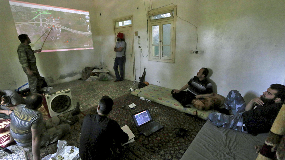 A rebel fighter briefs fellow fighters during an offensive against forces loyal to Syria''s President Bashar al-Assad on the frontline of Aleppo''s Sheikh Saeed neighbourhood