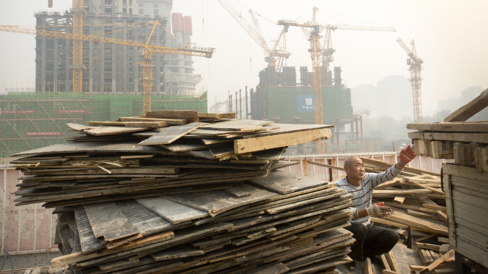 FILE - In this Oct. 6, 2015 file photo, a worker tosses boards