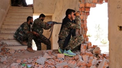 Kurdish People's Protection Units (YPG) fighters take up positions inside a damaged building in Hasakah city [Reuters]