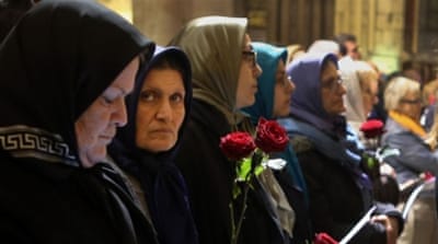 Muslim women pray at the Notre Dame Cathedral during a memorial service for the victims of the Paris attacks [Al Jazeera]