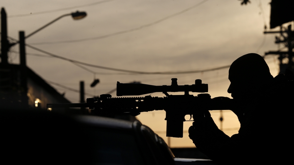 A sniper of Special Operations Battalion (BOPE) takes position at the Mare slums complex in Rio de Janeiro
