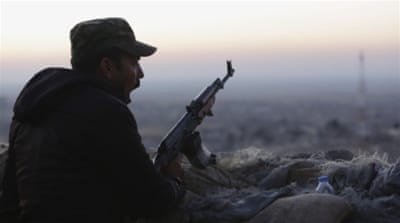 A Kurdish fighter, known as a peshmerga, yawns as he stands guard on the frontline in Sinjar, Iraq [AP]