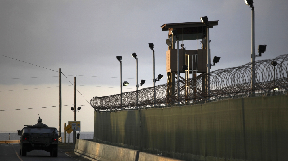 U.S. military, a U.S. trooper stands in the turret of a vehicle with a machine gun, left, as a guard looks out from a tower at the detention facility of Guantanamo Bay U.S. Naval Base in Cuba. [AP]