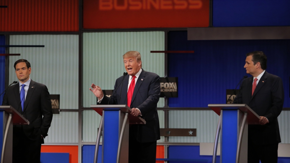 Republican US presidential candidate businessman Donald Trump speaks as rival candidates Senator Marco Rubio and Senator Ted Cruz look on [REUTERS]
