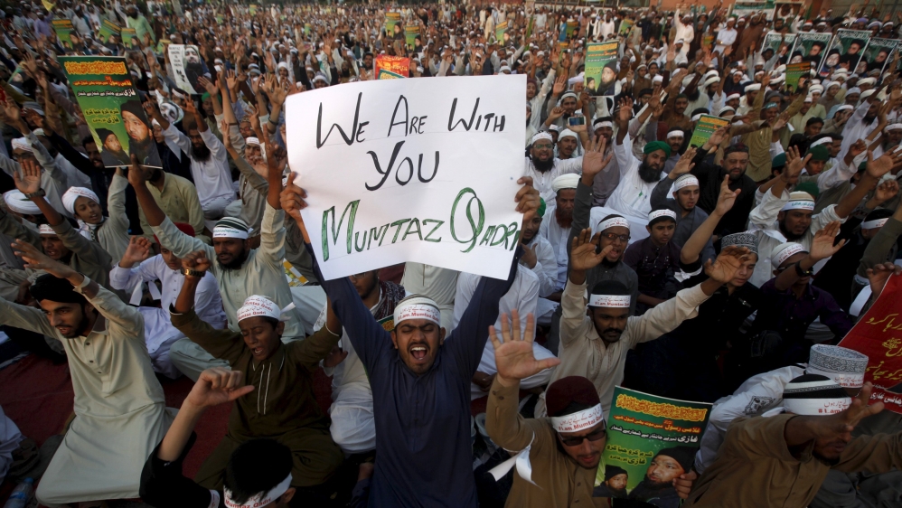 A supporter of the Ahle Sunnat religious political group holds a sign in support of convicted killer Mumtaz Qadri during a sit-in protest demanding his release in Karachi, Pakistan