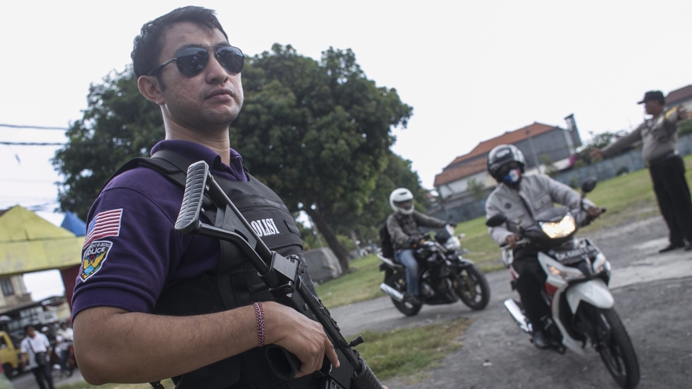 Indonesian policemen check motorcyclists during a road block to thwart an anticipate terrorism threat in Denpasar, Bali, Indonesia [EPA]