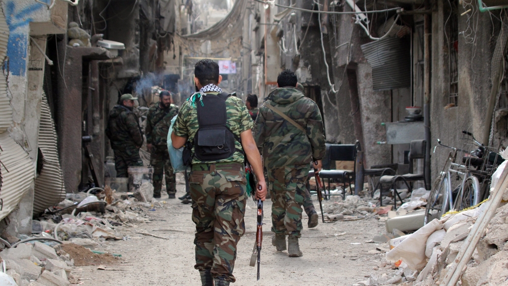 Palestinian fighters are seen walking at Palestine Camp near Damascus